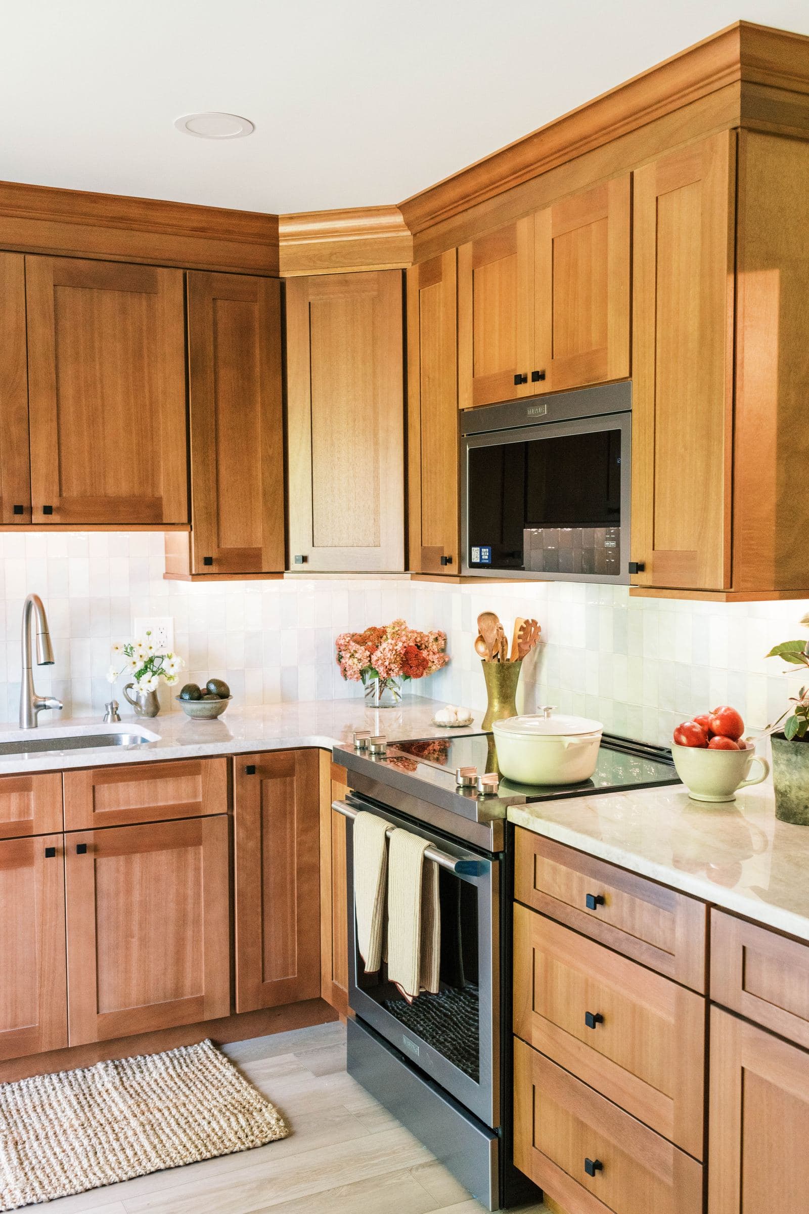 Warm wood shaker kitchen with a tile backsplash and stainless appliances
