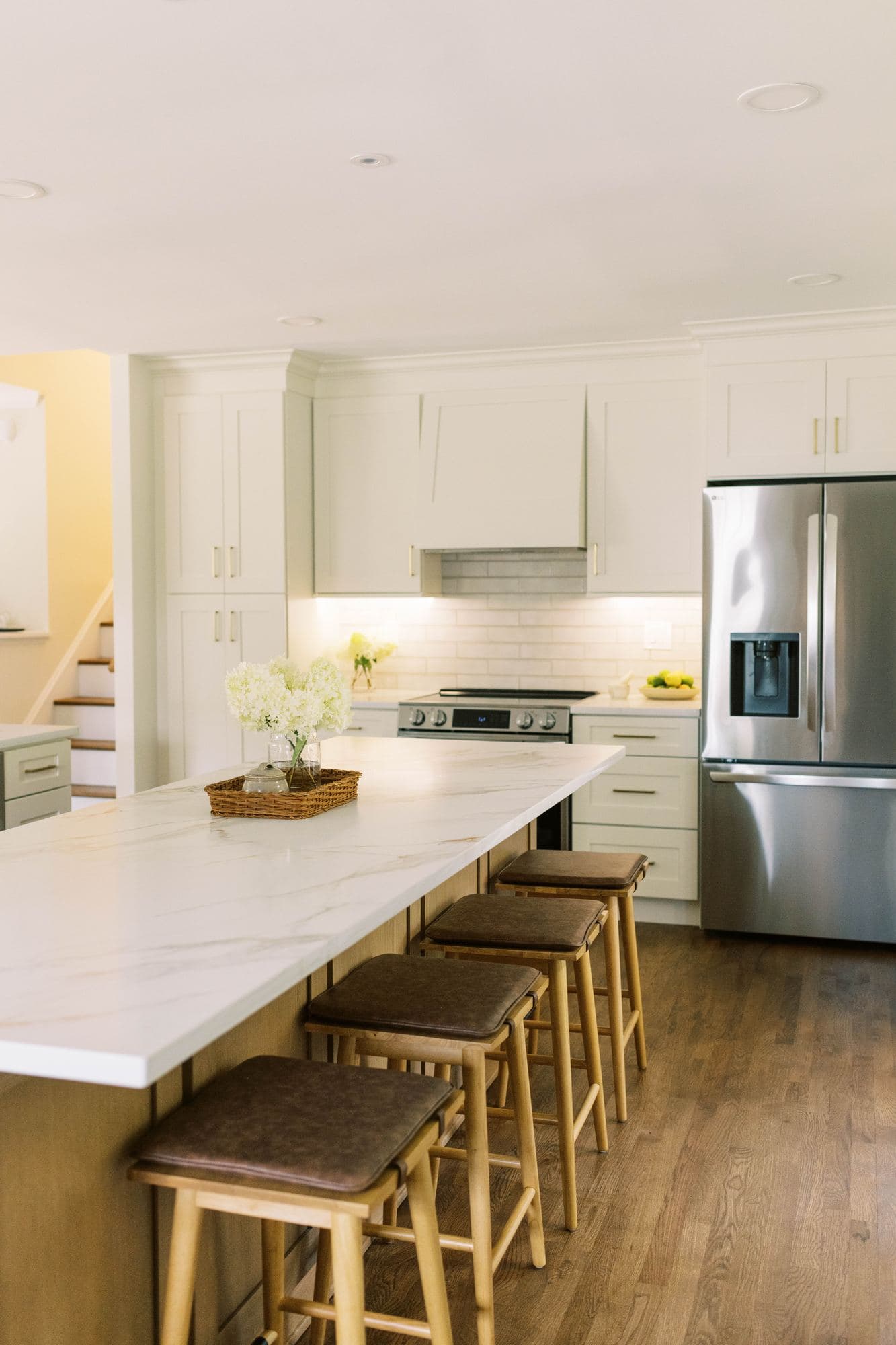 Long kitchen island with counter seating and a marble-look countertop