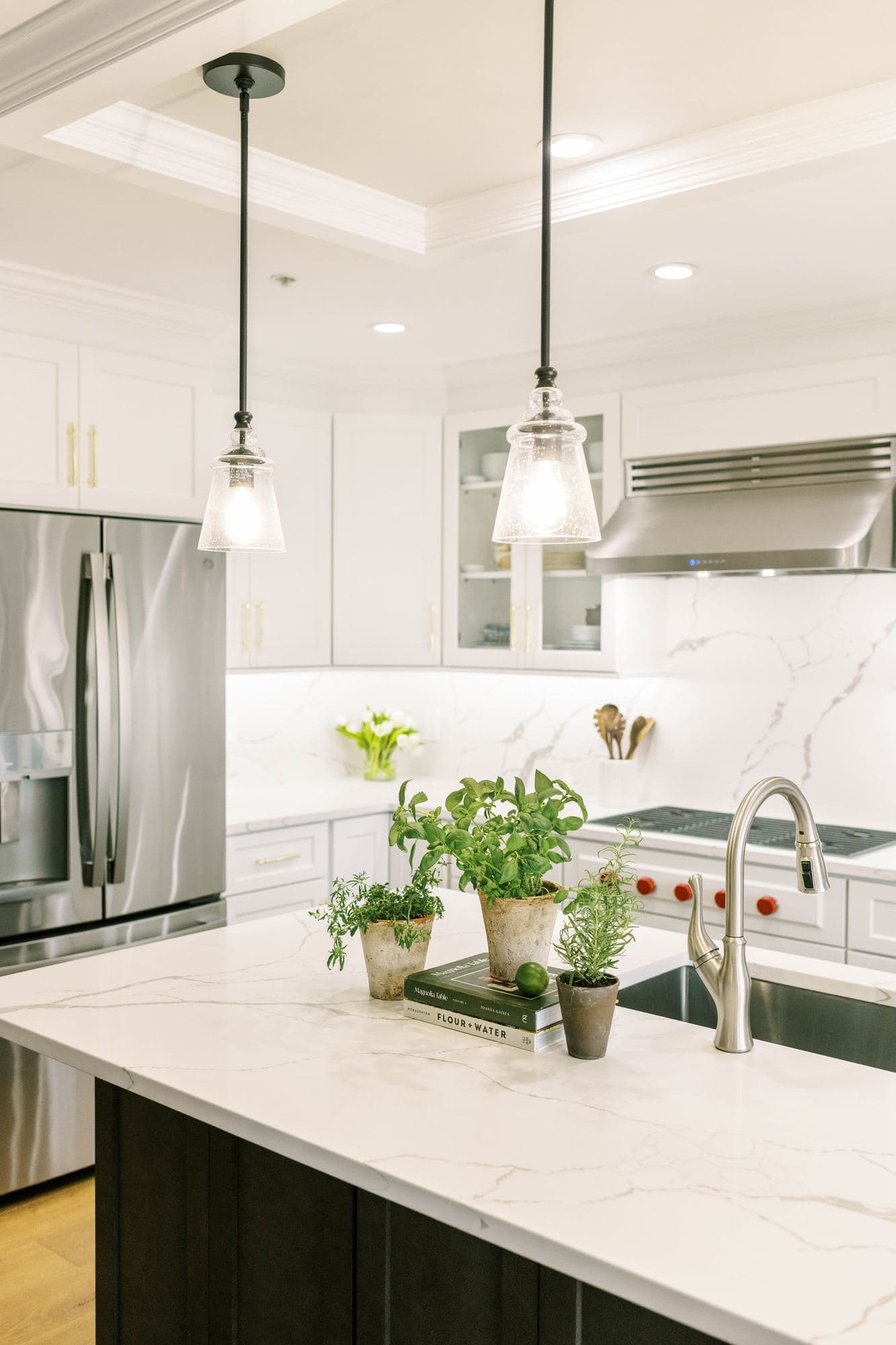 Kitchen island in front of a professional-style range under a tray ceiling